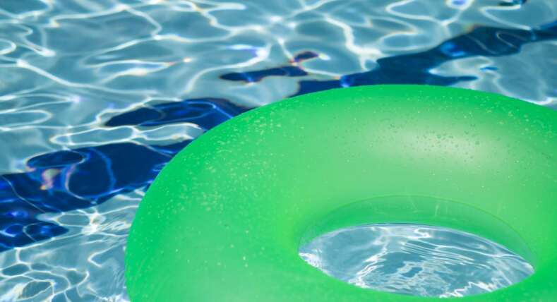 green-inflatable-pool-doughnut-floating-in-swimming-pool
