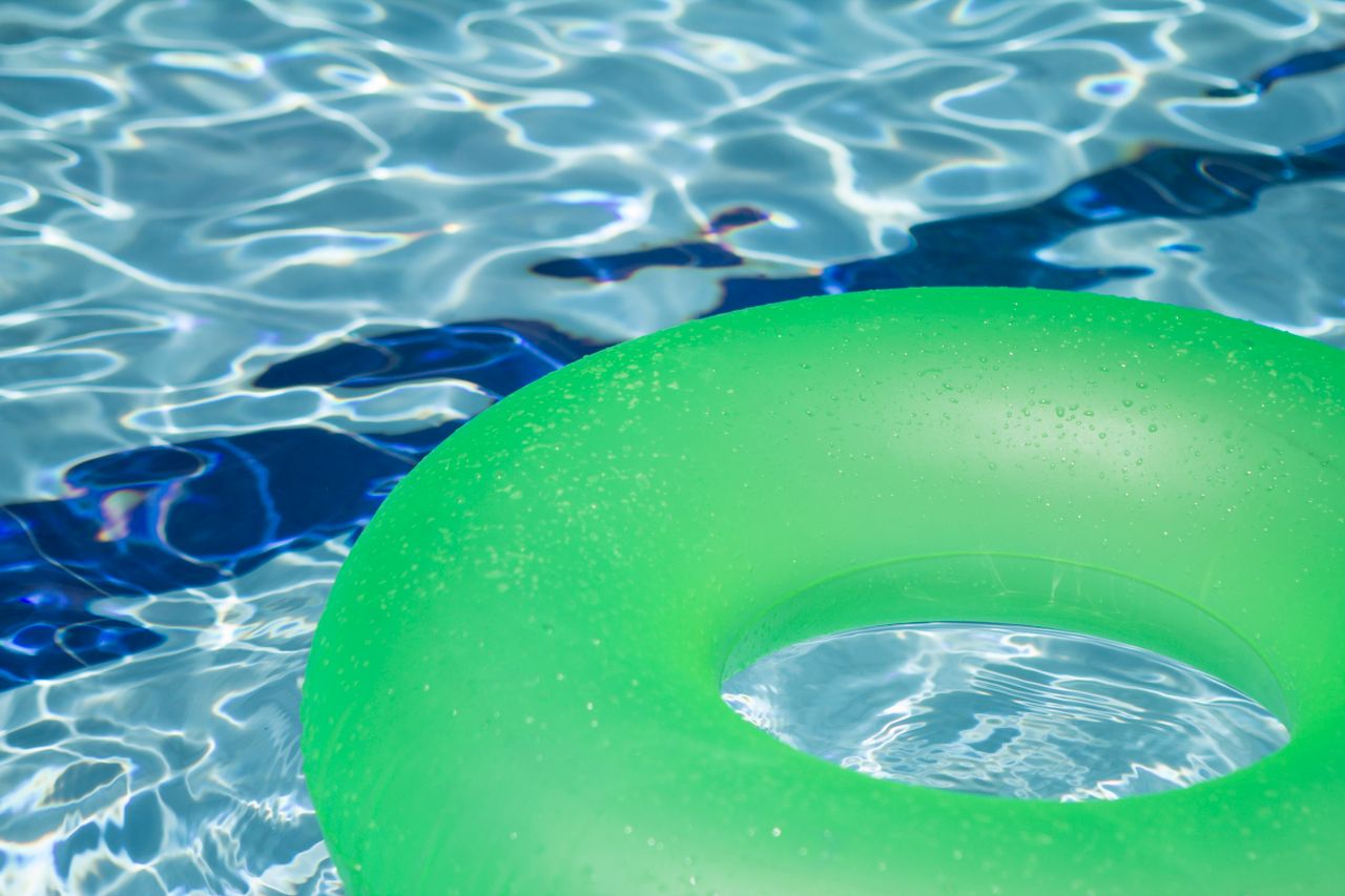 green-inflatable-pool-doughnut-floating-in-swimming-pool